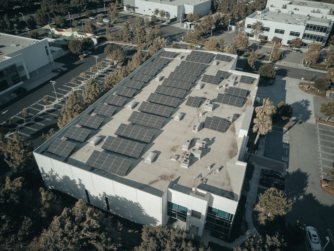 The Art of Drawing Readers In: Your attractive post title goes here Aerial shot of a commercial building with solar panels, emphasizing renewable energy architecture.